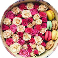 Arrangement of roses and Macarons in a round box