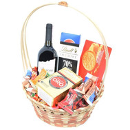 Basket of sweets with coffee and wine