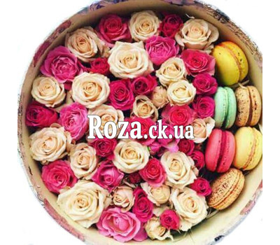 Arrangement of roses and Macarons in a round box